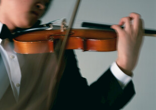 少年专注拉小提琴瞬间