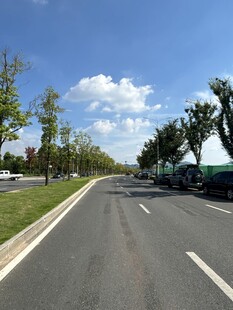 宽阔公路旁绿树蓝天白云