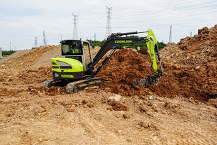 工地中的绿色挖掘机作业