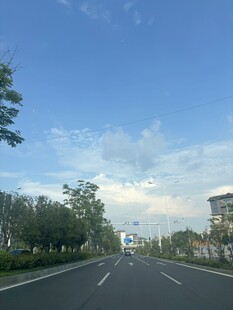 宽阔公路旁绿树蓝天白云