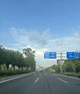 宽阔公路与路旁绿树蓝天