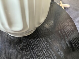 白色花瓶置于深色木质纹理表面