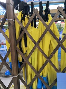 黄色防水衣物挂于栅栏旁