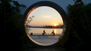 透过圆洞赏湖景划艇画面