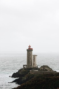 海边孤独灯塔屹立于礁石