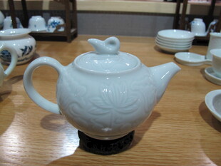 白色陶瓷茶壶置于桌上