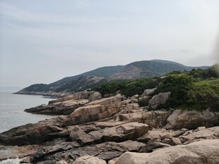 海边嶙峋岩石与葱郁山峦