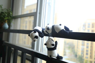 三只熊猫玩偶趴阳台护栏