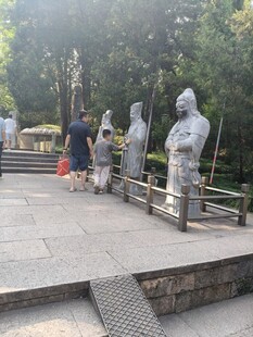 公园中游客赏古代人物雕像