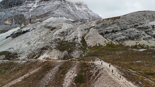 山间泥泞小路与远处雪山