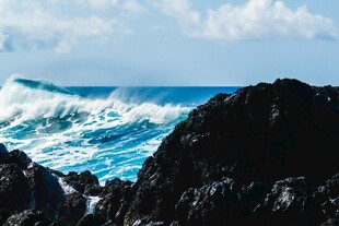 海浪拍击岸边黑色礁石