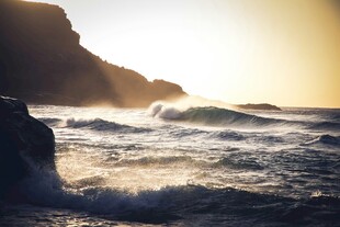 夕阳下的海浪与嶙峋礁石