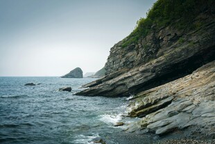 海边嶙峋岩石与远处孤峰