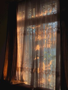 透过窗帘的温暖夕阳光影