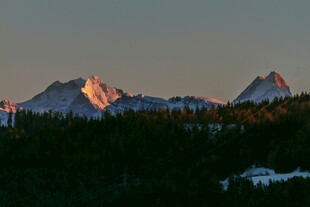 夕阳下的雪山与森林景观