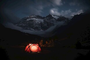 山间夜中亮灯的红色帐篷