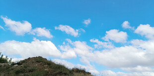 蓝天白云下的山丘景色