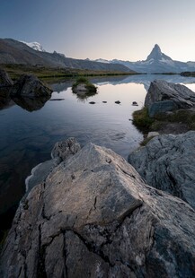 湖畔岩石与远处的壮丽山峰