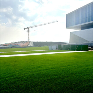 现代建筑旁的绿地与起重机