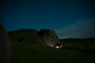 夜幕下的岩石与露营灯光