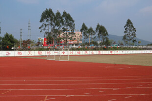 校园红色跑道与远处绿树