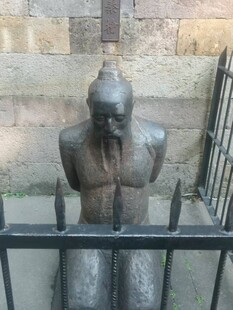 古老雕塑坐于围栏后