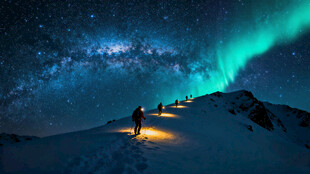 极光下的雪山徒步者