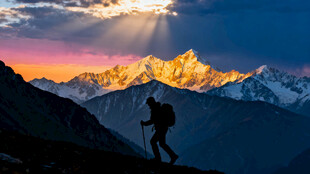 徒步者于山间赏壮丽日出