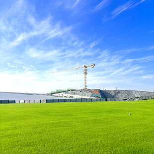 绿茵场上的塔吊与蓝天