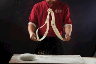 厨师展示手工制作长面条