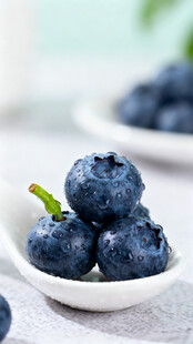 白碟中饱满新鲜的蓝莓