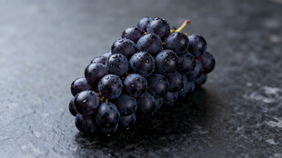 黑紫色葡萄置于深色台面