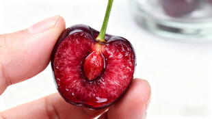 手捧切开的鲜红大樱桃