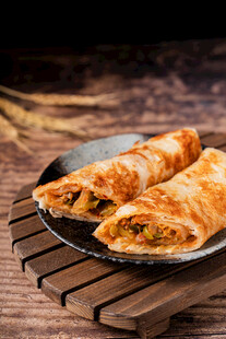 美味春卷置于木盘上