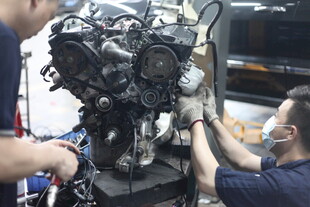 工人专注维修汽车发动机