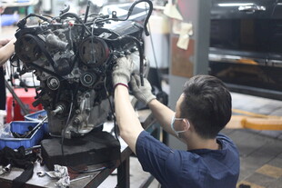 工人专注维修汽车发动机