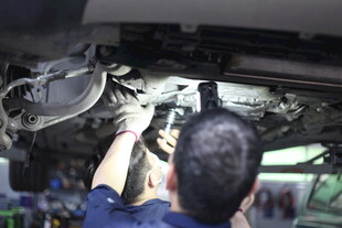 工人专注维修汽车底盘