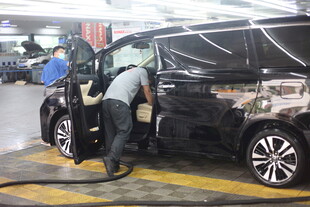 工人检修黑色轿车