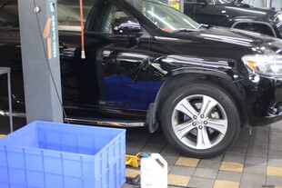 黑色SUV停于蓝色箱旁