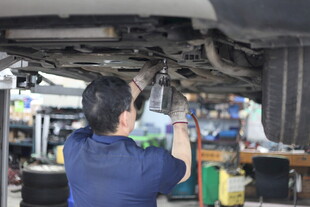 汽修工人专注检修汽车底盘