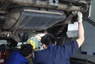 工人检修汽车底盘