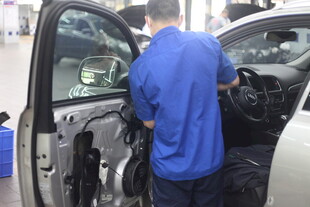 工人专注维修汽车内部