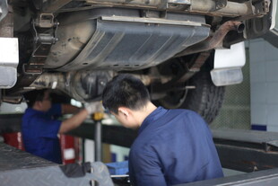 汽修工人专注检修汽车底盘
