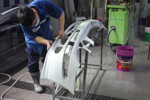 工人专注维修汽车部件