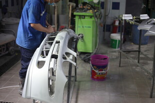 工人操作汽车部件加工