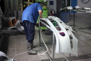 工人在车间喷涂汽车部件