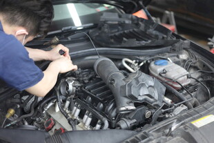 工人专注检修汽车发动机