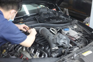 汽修工人专注检修汽车引擎