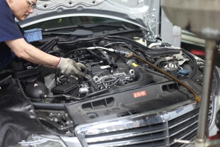 工人专注检修汽车发动机