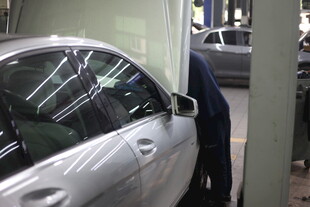 工人检修银色轿车